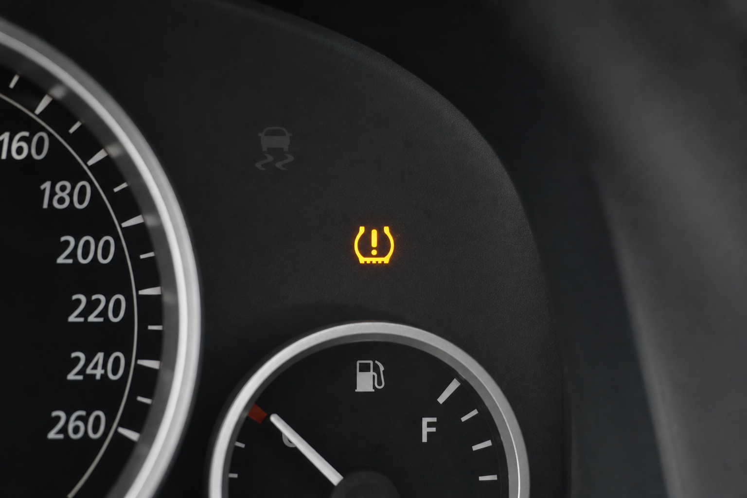 Car dashboard with TPMS tyre pressure warning light on